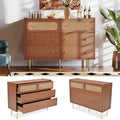 Hochschrank aus Rattan zeigt goldfarbene Griffe